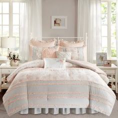 a bed with white and pink comforters in a bedroom