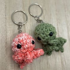 two crocheted keychains with black eyes and one has an octopus on it