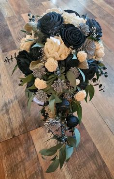 a bridal bouquet with black and white flowers on a wooden floor in a room