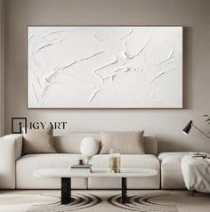 a living room filled with furniture and a large white painting on the wall above it