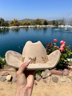 "Beige hat with yellow gold rhinestones on the bottom brim.  Beautiful butterflies line the trim.  This is one size fits most, there's a drawstring to adjust sizing.  ships in 2 business days! Stunning in person  Perfect for Coachella , stagecoach, Nashville, country concerts, bachelorette parties, brides, weddings Please note that the hats are handmade and may have some variances and blemishes. If any, they are very minor . The hats might have a bit of \"stickiness\" from the glue setting the rhinestones, this will improve over time." Gold Brimmed Hat For Rodeo, Gold Hat Bands For Rodeo Summer Events, Gold Hat Bands For Rodeo Summer, Gold Fedora Western Hat, Western Gold Brimmed Hat, Gold Western Fedora Hat, Gold Hat Bands For Rodeo In Summer, Gold Hat Bands For Summer Rodeo, Gold Hat Bands For Rodeo