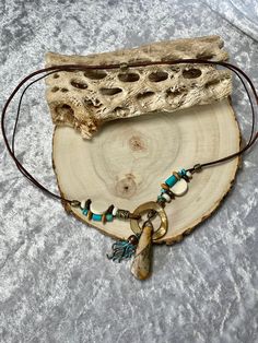 Detailed Picasso Jasper pendant hangs Lariat style with Turquoise, White and Turquoise Bone, Wood beads and a Mother of Pearl Loop to close. All on 2 leather cords, a 1mm dark brown and 2mm distressed brown. Picasso Jasper pendant is 1 1/2" long and 1/2" wide, around neck is 22" and total length of necklace is 24". A turquoise patina Octopus charm to the side that can be deleted of changed if you wish. To wear place open necklace around neck then put pendant thru the MOP ring from top. Adjust at will. No lead or nickel used. Please use the Last On, First Off approach. Stones discolor with lotions, perfumes, hairspray, sweat, chlorine, even some soaps, and will break if dropped. Adjustable Dangle Lariat Necklace, Unique Lariat Necklace With Natural Stones For Gifts, Adjustable Turquoise Lariat Necklace, Adjustable Beaded Turquoise Lariat Necklace, Adjustable Beaded Lariat Turquoise Necklace, Bohemian Beaded Necklaces With Teardrop Natural Stones, Rustic Adjustable Necklace With Natural Stones, Artisan Lariat Necklace For Festivals, Bohemian Turquoise Necklace With Adjustable Cord