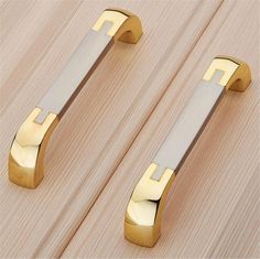 two metal handles on wooden surface with wood grain