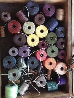 several spools of thread in a wooden box