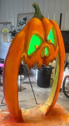 a pumpkin carved into the shape of a crescent with glowing eyes and mouth, sitting on a table