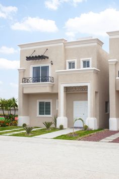 a two story house with an attached balcony and balconies