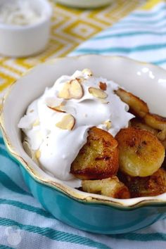 a bowl filled with bananas and cream on top of a blue and white table cloth