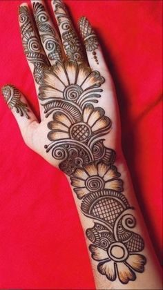 a woman's hand with henna tattoos on it