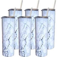 four white marbled tumblers with straws in them are lined up against each other