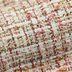 a close up view of a piece of fabric with gold and red beads on it