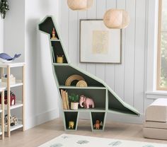 a child's room with toys and bookshelves in the shape of a dinosaur