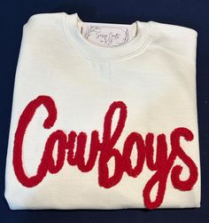 This listing is for 1 custom chenille yarn embroidered sweatshirt.  We can do several different color combinations.  This listing is for the word Cowboys only. You can change your colors but this listing is not for a new  word.  When checking out please leave the color combination wanted.   We do not recommend doing white chenille yarn on black sweatshirts.  Machine wash cold, do not soak or bleach. For best results dry flat, but I do dry mine on low. Do not iron the chenille; it will melt. For Game Day White Sweatshirt With Embroidered Graphics, White Game Day Sweatshirt With Embroidered Graphics, White Team Spirit Sweatshirt With Embroidered Graphics, White Sweatshirt With Embroidered Graphics For Team Spirit, White Collegiate Sweatshirt With Custom Embroidery, White Embroidered Logo Sweatshirt For Game Day, White School Spirit Sweatshirt With Letter Embroidery, White Collegiate Sweatshirt With Letter Embroidery, White Embroidered Collegiate Sweatshirt