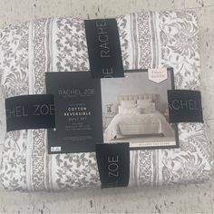 a bed with white sheets and black tags on the covers, along with two price tags for each piece