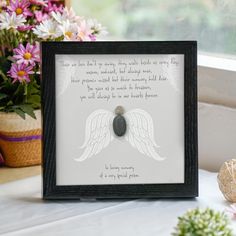 an image of a frame with a quote on it and flowers in the back ground