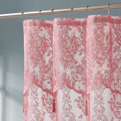 pink lace curtains hanging on a metal rod