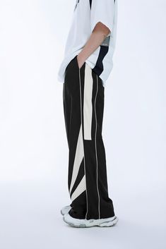 Expertly designed with a geometric pattern, these dark grey and black wide-leg pants feature side stripes for a bold look. Made with a cotton blend fabric and nylon composition, the loose fit provides comfort and style. Available in sizes S-XL for men. Sporty Wide Leg Pants For Streetwear, Streetwear Wide Leg Bottoms With Side Stripes, Black Pants With Contrast Stripes For Streetwear, Black Wide-leg Pants With Contrast Stripes, Black Wide Leg Pants With Contrast Stripes, Black Straight Pants With Elastic Side Panels, Sporty Wide-leg Pants With Side Stripes, Sporty Black Wide Leg Pants, Black Straight Leg Pants With Elastic Side Panels