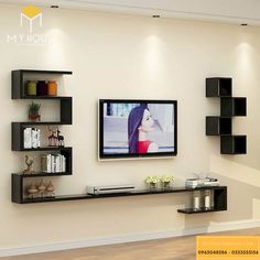 a flat screen tv mounted to the wall in a living room with shelving units