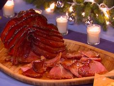 a large platter of meat and cheese on a blue table cloth with candles in the background