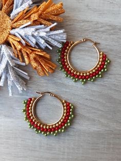 Gold hoop earrings with gold, red and green beads woven around the hoop earring. The hoop earrings are made or stainless steel and remain the color. Hoop earrings is 1,18 inches round and the beads are 0,12 inches round. The earring has a locked clasp.  The earrings are light and comfortable to wear. These earrings are a jewel for your face. Beautiful gift for birthday, Christmas, mother, daughter or friends. The jewelry is sent in a box or in a organza bag. The jewelry will be packages in a bub Light Earrings, Green Beads, Gift For Christmas, Green Bead, Gold Hoop, Organza Bags, Bead Weaving, Gold Hoop Earrings, Mother Daughter