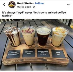 a wooden tray topped with four different types of coffees on top of a table