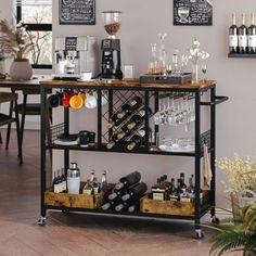 a bar cart filled with bottles and glasses on top of a hard wood floor next to a dining room table