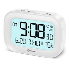 the alarm clock is white and has blue numbers on its face, as well as two different time zones