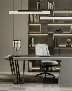 an office desk with a chair and bookshelf in the background