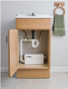 an open cabinet with a sink and towel hanging on the wall above it in a bathroom