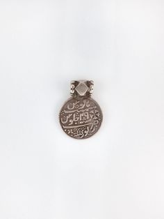 "A truly special antique Indian devotional charm worn during Islamic pilgrimages.  measurements: 1\" circumference  material: 800 silver  circa: 1920s" Traditional Medallion Necklace With Vintage Charm, Vintage Medallion Jewelry For Rituals, Traditional Necklaces With Vintage Charm And Round Pendant, Engraved Coin-shaped Amulet Jewelry, Traditional Pendant Jewelry With Vintage Charm, Traditional Vintage Charm Pendant Jewelry, Traditional Ceremonial Jewelry With Vintage Charm, Spiritual Coin Locket Jewelry, Vintage Ceremonial Jewelry With Coin Pendant