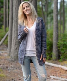 a woman is standing in the woods smiling