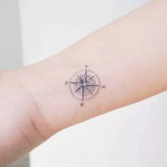 a small compass tattoo on the wrist