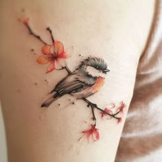 a small bird sitting on a branch with flowers around it's neck and arm