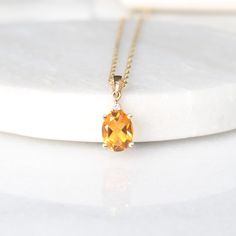 "This beautiful pendant features a citrine stone at the center with a single sparkling diamond set above, in classic 10k yellow gold setting. This pendant would make a beautiful for any citrine lover! Matching earrings also available.  Measures (approx.) 8.9 mm x 7 mm (without the bail) Gemstones: One genuine oval-cut citrine (approx. 8.9 mm x 7 mm) One genuine round-cut diamond (0.01 cts) Metals: 10k yellow gold NOTE: This pendant can be purchased separately or with a 10k yellow gold twisted singapore chain with spring closure (as shown) in either 18\" or 20\". If you are interested in other chain options, please contact us and we will work with you to find the perfect choice from the extensive selection of we offer. | c u r a t e d | Visit our website for curated and modern pieces  https Oval Citrine Gemstone Necklace, Citrine Pendant, Citrine Necklace, Sparkling Diamond, Yellow Gold Setting, Citrine Stone, Gemstone Jewellery, Citrine Gemstone, Diamond Set