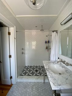 a bathroom with a shower, sink and mirror