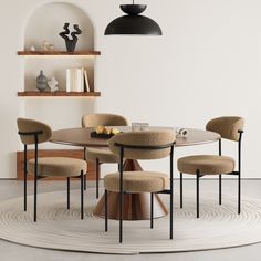 a round table with four chairs around it in a white dining room area that has an oval rug on the floor and shelving