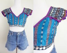 D E T A I L S  - Vintage Indian crop top - So many beautiful details~ embroidery, silk panels, metallic threads, beading, sequins & trim - Open back that ties closed in three places, front is fully lined - Very good condition, may be missing some sequins here and there M E A S U R E M E N T S  - Womens extra small, please see measurements below - Armpit to armpit 18" - Length 13" * to convert inches to centimeters please multiply by 2.54 ** tip: for a sure fit, take a similar item & measure as w Festive Summer Top With Mirror Work, Blue Fitted Tops With Intricate Embroidery, Fitted Blue Tops With Intricate Embroidery, Fitted Blue Tops With Mirror Work, Blue Party Top With Mirror Work, Fitted Sequin Tops For Festivals, Blue Mirror Work Party Top, Embroidered Fitted Bohemian Crop Top, Fitted Summer Blouse With Mirror Work