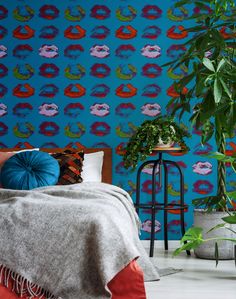 a bedroom with blue wallpaper and plants in the corner