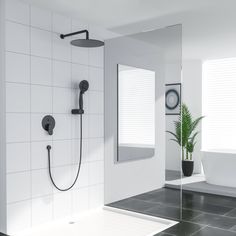 a bathroom with a shower head, mirror and bathtub