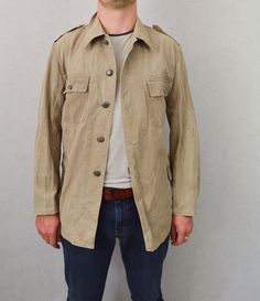 "Vintage Stone Canvas Chore Worker Jacket - 100% Cotton Tough Faded Military - S M L XL Rugged tailored military design in a stunning faded stone wash grey/desert brown canvas fabric that makes the perfect midweight jacket. Metal buttons, two front pockets and epaulettes to shoulders. Most will not be decorated but there may be a few with badges to collar or chest which can be easily removed if desired. - Original Swedish tagging within - Unlined - Dated 1950s-60s - Made from thick, durable cott Vintage Hunting Jacket, Vintage Hunting Outerwear With Button Closure, Vintage Military Jacket, Brown Military Style Hunting Outerwear, Military Style Cotton Hunting Outerwear, Worker Jacket, Military Army, Military Design, Brown Canvas