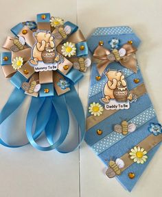 two blue and gold ribbons with cartoon characters on them, one for baby to be