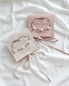 two bridesmaid bracelets and a card on a bed