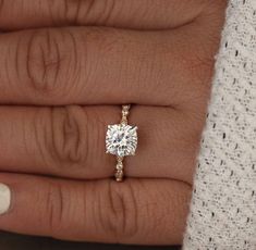 a woman's hand with a engagement ring on it and a diamond in the middle