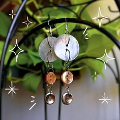 the earrings are hanging from the metal stand with stars on it's back drop them off