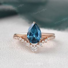 an engagement ring with a blue topazte surrounded by white diamonds on a blanket