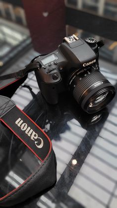 a camera sitting on top of a table next to a bag