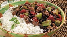 a close up of a bowl of food with rice and vegetables on a table cloth