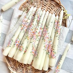 some white candles are sitting in a wicker basket