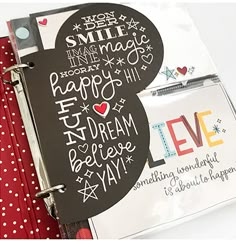 an open mickey mouse notebook with writing on the cover and red polka doted fabric