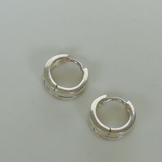 Thick band ear hoops made of sterling silver with a hinged joint. Dimensions: 12 X 5 mm Price listed is for a pair of hoops. These earrings are made of 925 hypoallergenic sterling silver. All my pieces are sent in a gift box. I can include a personal message from you if needed. You are welcome to contact me at... bhavnakwintra1956@gmail.com More hoops: https://www.etsy.com/your/shops/TheSilverGame/tools/listings/section:26305414 More earrings: https://www.etsy.com/your/shops/TheSilverGame/tools/ Trendy Silver Hoop Cartilage Earrings, Modern Round Silver Cartilage Earrings, Adjustable Silver Hoop Huggie Earrings, Adjustable Minimalist Sterling Silver Huggie Earrings, Modern Silver Hoop Earrings With Simple Design, Silver Sterling Hoop Earrings With Simple Design, Dainty Adjustable Silver Huggie Earrings, Simple Silver Cartilage Earrings, Silver Huggie Earrings For Everyday