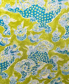 a green and blue fabric with dragon designs on it